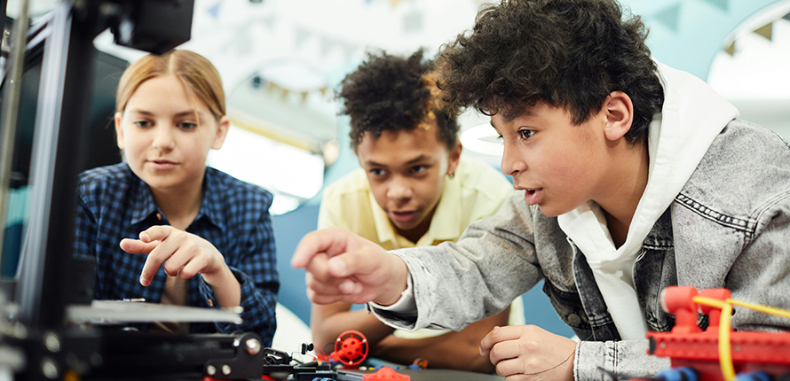 Children working on a computer with robotic toys